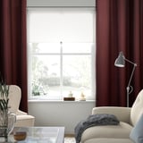 Living room with burgundy SPIRBJÖRNBÄR curtains, blocking light, and offering privacy.