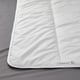 Clean, white duvet with smooth fabric and stitches falling diagonally, placed on grey bedding.