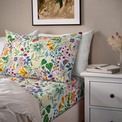 White floral bedding set with flat sheet and pillowcases.