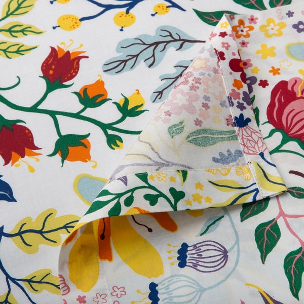 Flat sheet with vibrant floral print on soft, white cotton. Pillowcase folded neatly atop.