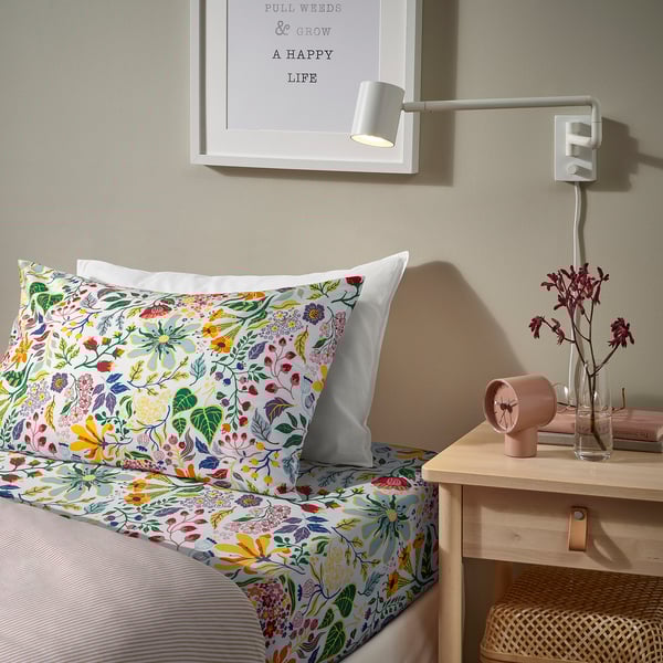 White cotton bedding with colourful flowers; modern design, fits bed smaller than framed quote.