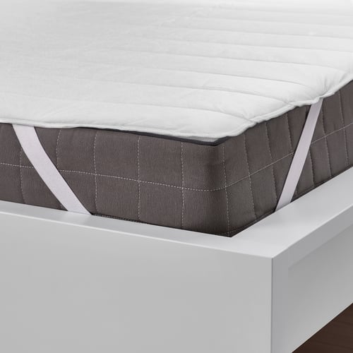 Mattress protector on white bed, elastic straps ensure it stays in place, protects from stains.