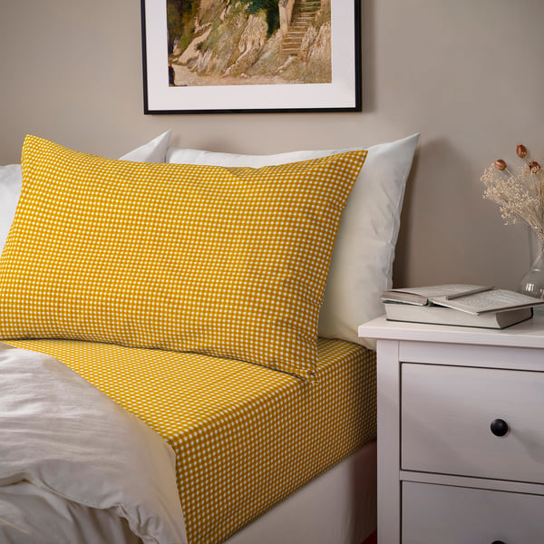 Bright yellow chequered bedding, including fitted sheet and pillowcases, adds a fresh vibe to a cosy bedroom.