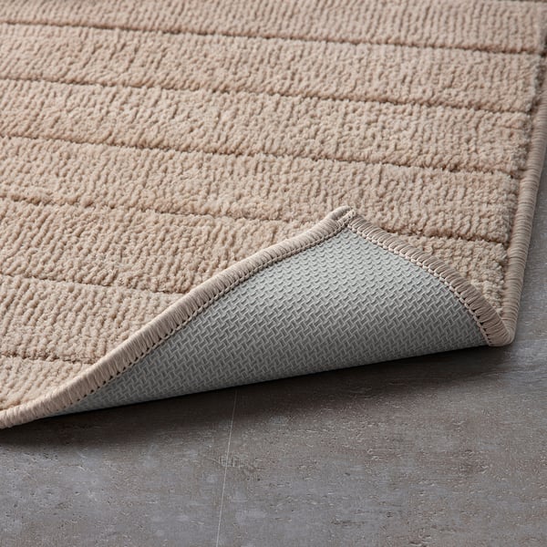 Bath mat with textured surface for grip, soft material, and latex backing.