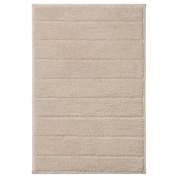 Beige TIDNINGSBUD bath mat with horizontal stripes, textured recycled polyester for quick drying.
