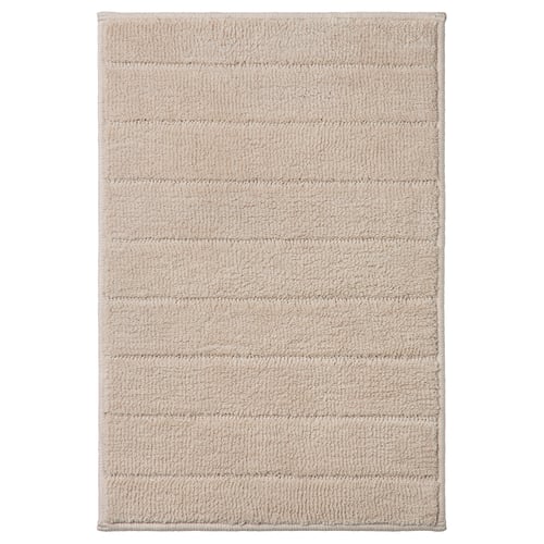 Beige TIDNINGSBUD bath mat with horizontal stripes, textured recycled polyester for quick drying.
