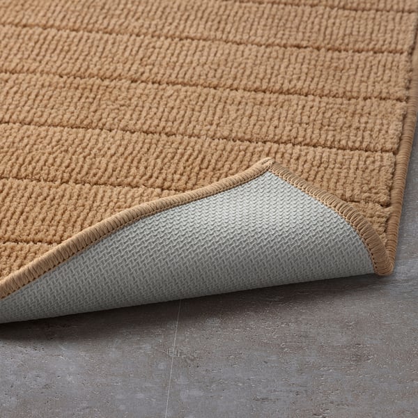 Bath mat with soft, textured surface and non-slip backing.