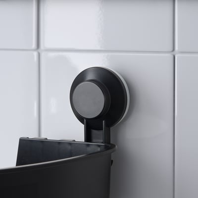 A black TISKEN corner shelf with suction cups for bathroom storage.