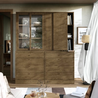 Wooden cabinet by window with glass doors and drawers.