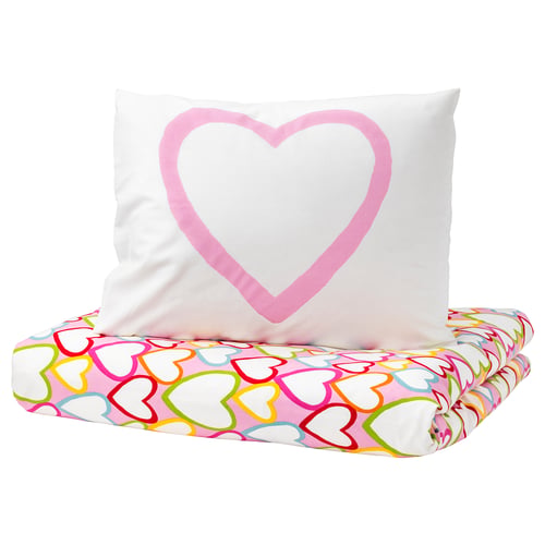 Heart-shaped pillow on heart-patterned pillowcase.