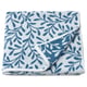 Folded blue-and-white leaf-patterned bath towel made of cotton.