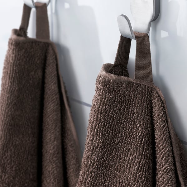 Two brown towels hang neatly on silver hooks; one looped through its corner, showcasing functional design for easy hanging.