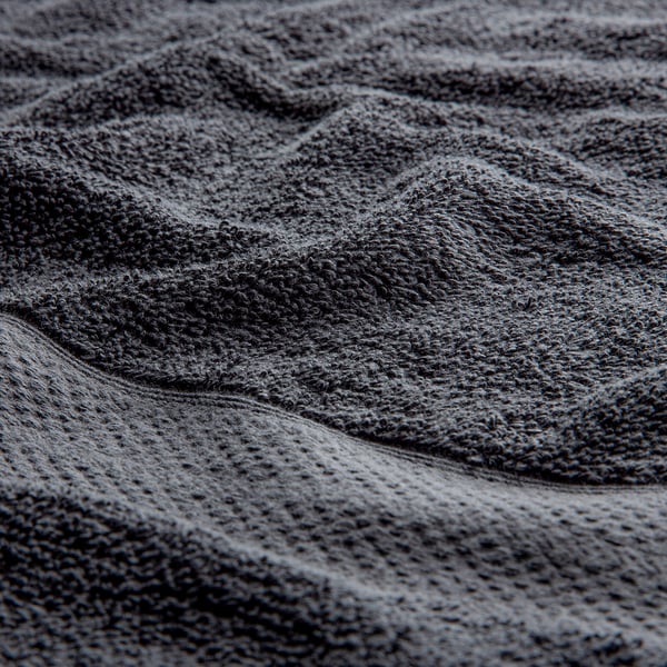 Close-up of soft, high-quality grey cotton towel, showcasing its textured, absorbent surface.