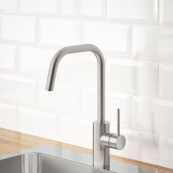 Rubinetto da cucina moderno, acciaio inossidabile, bancone in legno, alzatina in piastrelle bianche, efficiente in termini idrici.
