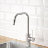 Rubinetto da cucina moderno, acciaio inossidabile, bancone in legno, alzatina in piastrelle bianche, efficiente in termini idrici.