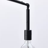 Moderna lampada da terra nera con collo regolabile e lampadina a vista, ben costruita ed elegante.