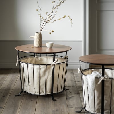 Tavolo contenitore Aebyn: piano in legno, tessuto beige, struttura in metallo nero; multiuso dal design rustico.