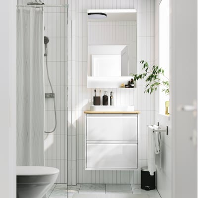 Bagno moderno con lavabo ÄNGSJÖN, lavabo in marmo, doccia in vetro, grande specchio e pianta.