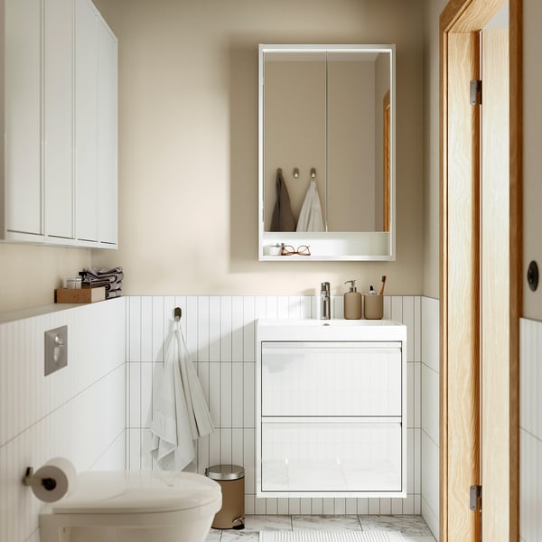 Bagno minimalista con lavabo ÄNGSJÖN, lavandino, dispenser beige, specchio e asciugamano bianco.