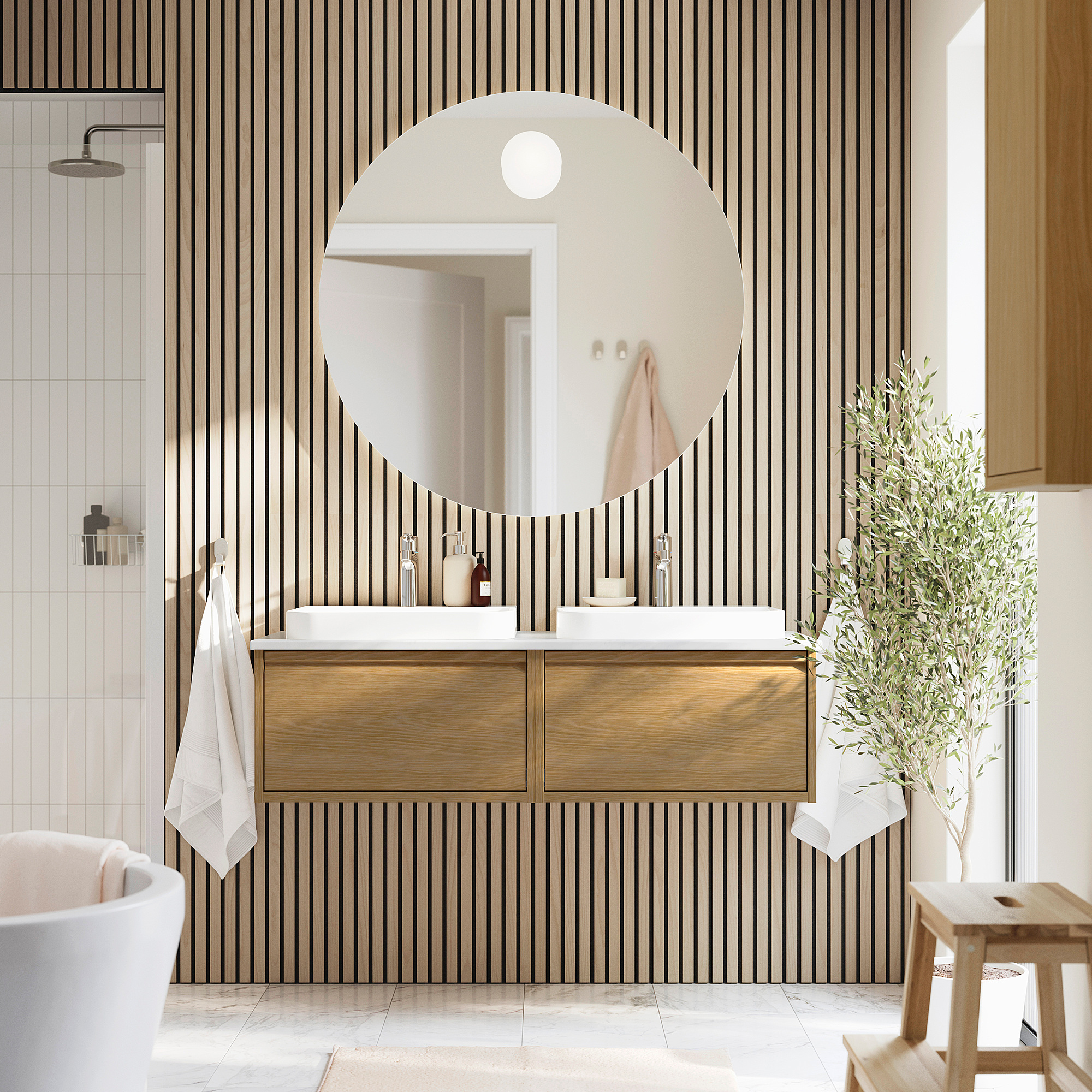 Bagno moderno con lavabo ÄNGSJÖN in rovere, specchio, pianta. Pareti a strisce bianche e nere.