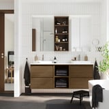 Bagno moderno con lavabo ÄNGSJÖN in rovere marrone, mensole a giorno, specchio e pianta.