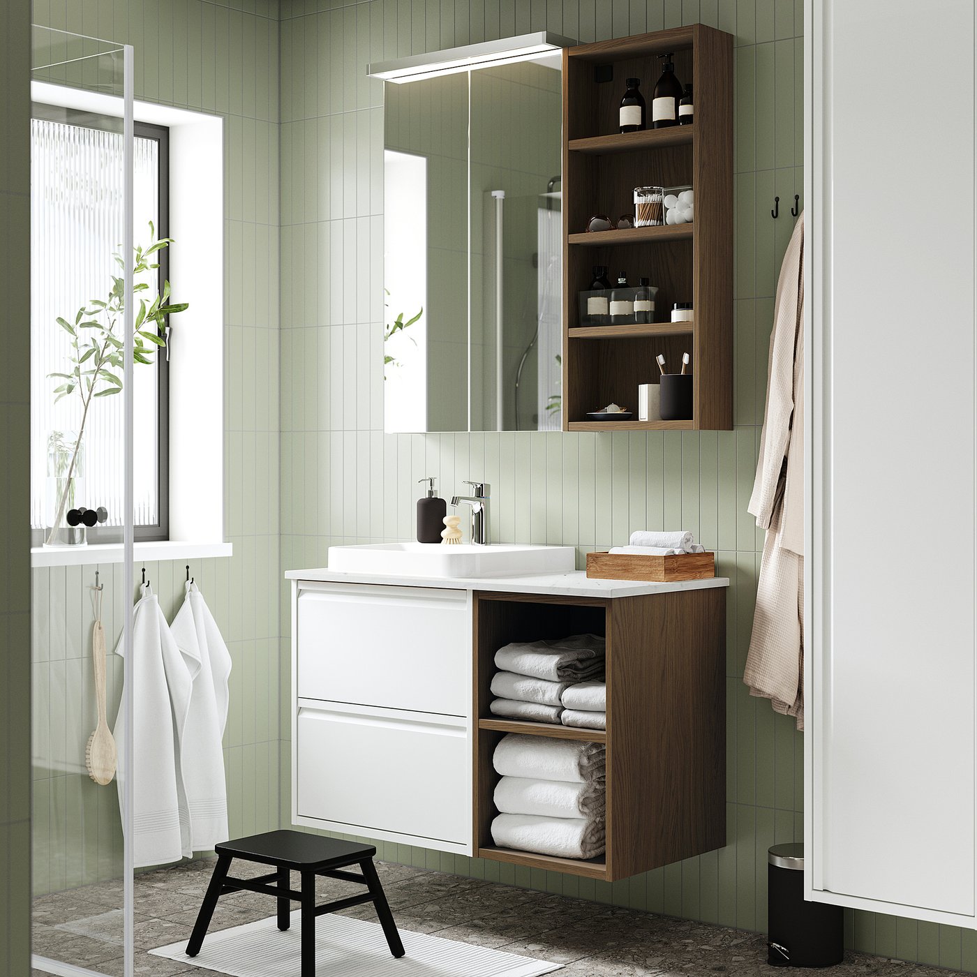Moderno bagno verde con lavandino bianco, mensole in legno e asciugamani appesi.