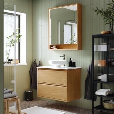 Bagno moderno con lavabo in rovere ÄNGSJÖN, lavabo in marmo e pareti verde salvia.