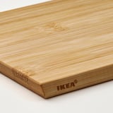 Tagliere in legno con un angolo leggermente rialzato, con il logo ikea inciso sul bordo.