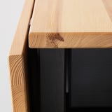 Primo piano del bordo del tavolo ARKELSTORP, piano in legno chiaro, base scura, che mostra artigianalità e qualità.