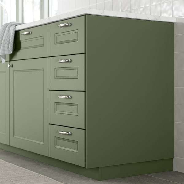 Mobile da cucina verde con maniglie in argento.