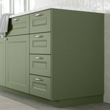 Mobile da cucina verde con maniglie in argento.