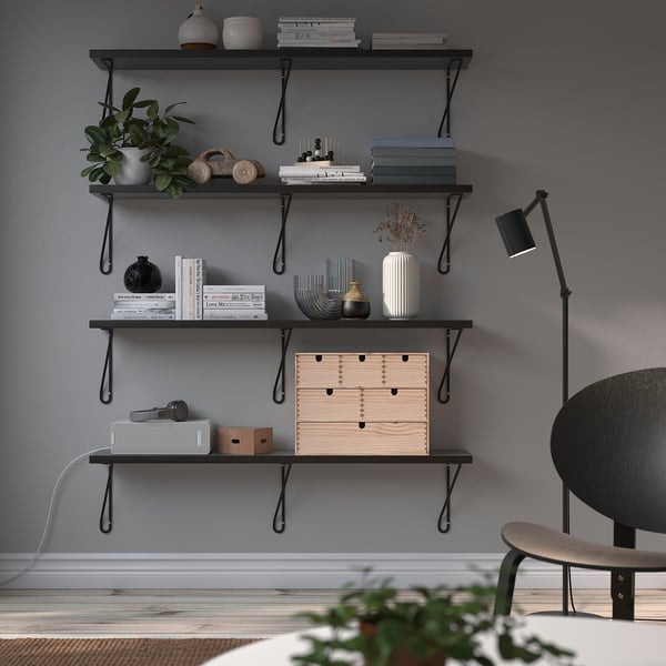 Scaffali in metallo nero con piante, libri e decorazioni. Supporto a parete alto per soggiorno o ufficio. Design elegante e minimalista.
