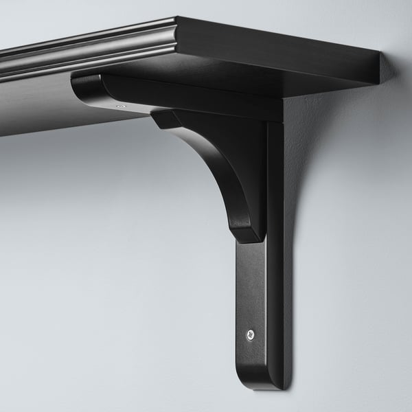 Mensola da parete nera dal design elegante, con un bordo liscio e uno smussato, montata saldamente su una parete.