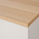 Piano del tavolo BESTÅ con superficie in legno e gambe bianche, che mostra la qualità artigianale.