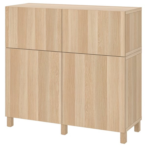 Mobile in legno chiaro, BESTÅ. Due sezioni con quattro porte, forma rettangolare, design robusto.