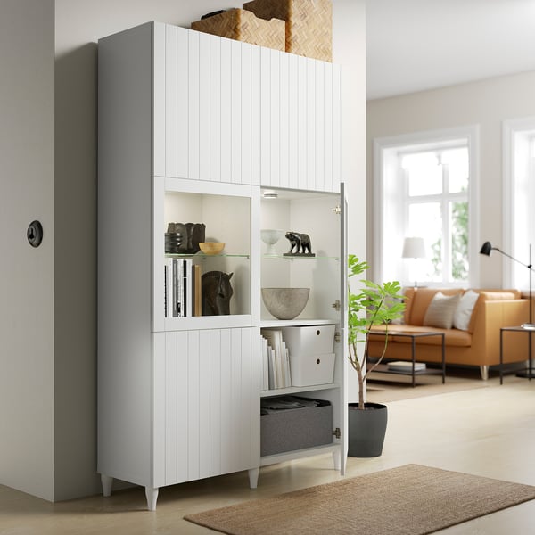 Soggiorno moderno con mobile BESTÅ bianco che mostra la combinazione di archiviazione ed esposizione, libri e decorazioni.