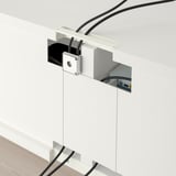 Un moderno porta tv con ripiani regolabili e gestione dei cavi. I cavi sono instradati ordinatamente attraverso la parte posteriore, mantenendo l'area ordinata.