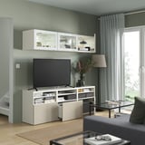 Soggiorno moderno con mobile tv BESTÅ, ripiani regolabili, passacavi e vetrine. Tv centralizzata con un cassetto.