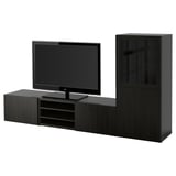 Moderno mobile tv BESTÅ nero con contenitore. TV a schermo piatto su ampio ripiano, due cassetti e ante in vetro. Design elegante e minimalista.