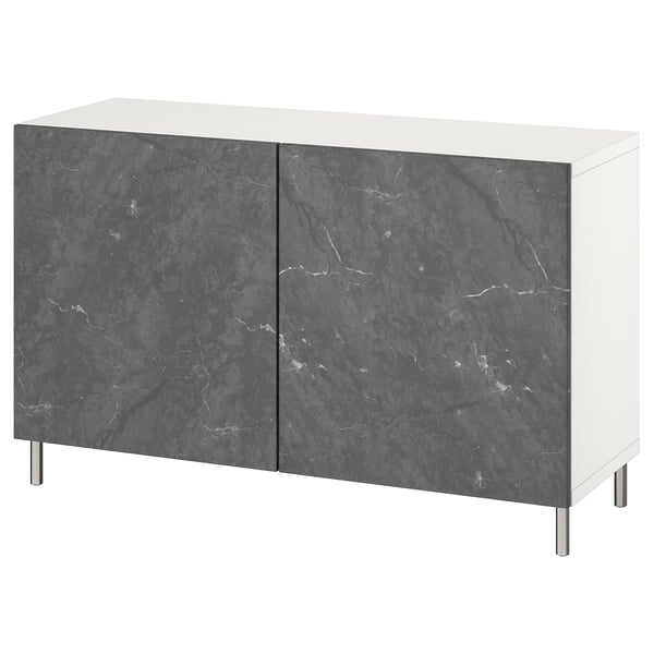 Questa immagine mostra una credenza moderna in marmo bianco e nero di BESTÅ. Si tratta di due ante con motivo marmo scuro, sorrette da gambe in acciaio inox.
