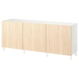 Una credenza in legno bianco e chiaro con quattro ante di forma rettangolare.