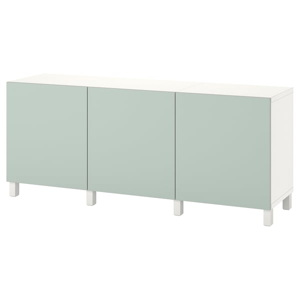 Una credenza ikea BESTÅ bianca con tre ante verde chiaro. Ha un design moderno con gambe quadrate e cerniere regolabili.