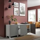 Soggiorno moderno con credenza BESTÅ grigia, decorato con vasi, fiori e foto incorniciate. Divano arancione nelle vicinanze.