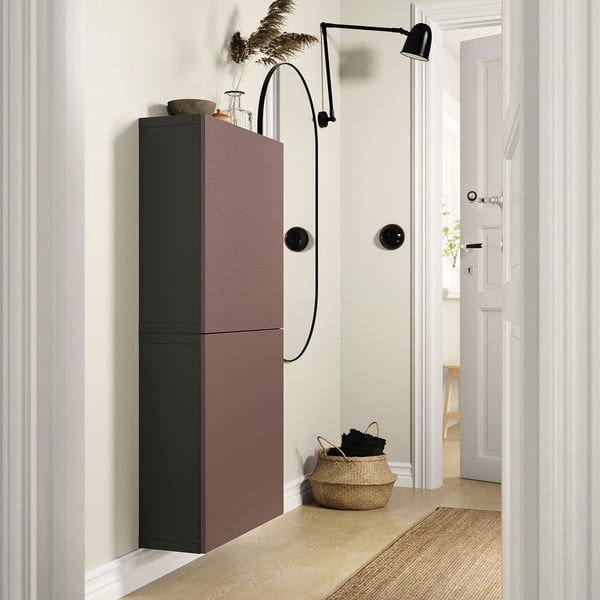 Corridoio moderno con armadietto BESTÅ marrone e nero, lampada da parete e cestino.
