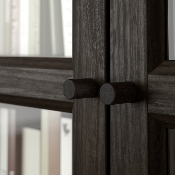 Porta in legno scuro con maniglie cilindriche, lavorazione dettagliata.