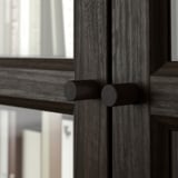 Porta in legno scuro con maniglie cilindriche, lavorazione dettagliata.