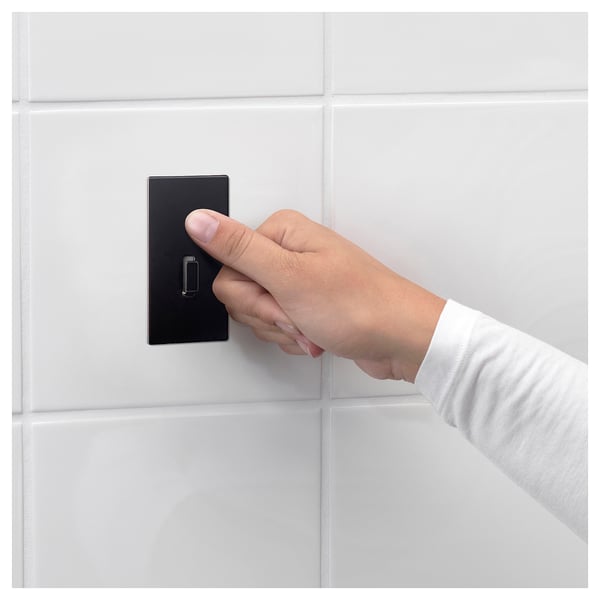 La persona gira l'interruttore a muro nero; Design moderno e minimalista.