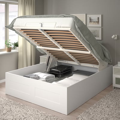 Letto moderno con base sollevabile che rivela un vano portaoggetti nascosto, ideale per biancheria da letto extra o documenti.