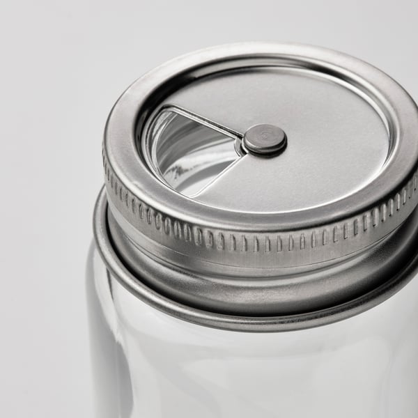 Barattolo in vetro con coperchio in acciaio inox, dotato di meccanismo flip-top. Il coperchio ha un bordo sigillato e testurizzato per una chiusura sicura.