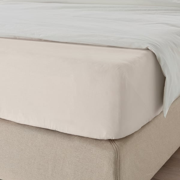 Un letto ben fatto con un lenzuolo con angoli DVALA in colore neutro, che mette in mostra il suo bordo elastico.